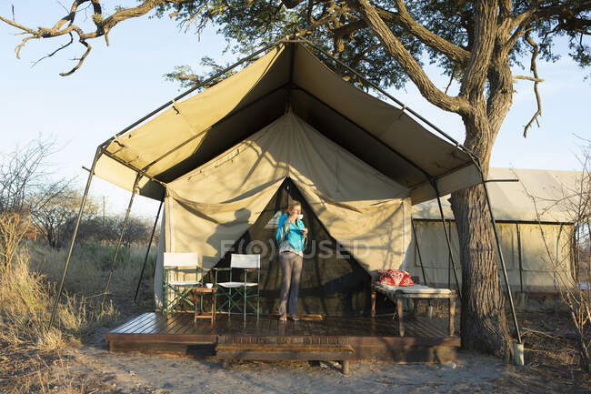 Una giovane ragazza fuori dalla tenda in una riserva naturale nel deserto del Kalahari. — Foto stock