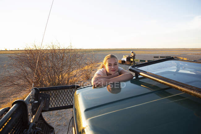 Ein junges Teenager-Mädchen auf dem Dach eines Safarifahrzeugs. — Stockfoto