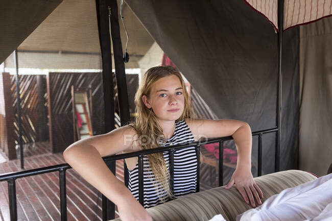 Ein zwölfjähriges Mädchen neben einem Bett im Zelt. — Stockfoto
