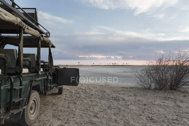 Véhicule Safari avec vue sur le paysage de la marmite salée, désert du Kalahari. — Photo de stock