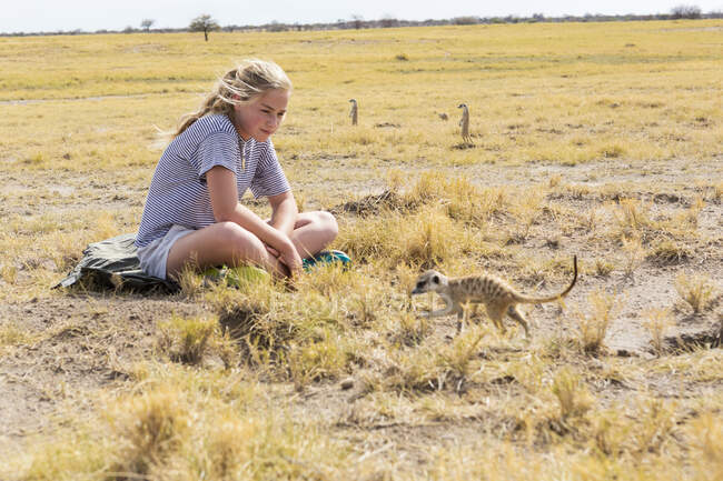 Menina de 12 anos olhando para Meerkats, Kalahari Desert, Makgadikgadi Salt Pans, Botsuana — Fotografia de Stock