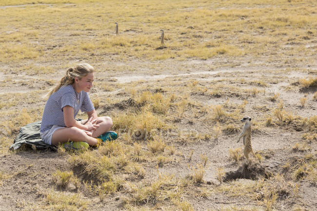 Ragazza di 12 anni che guarda Meerkats, Kalahari Desert, Makgadikgadi Salt Pans, Botswana — Foto stock