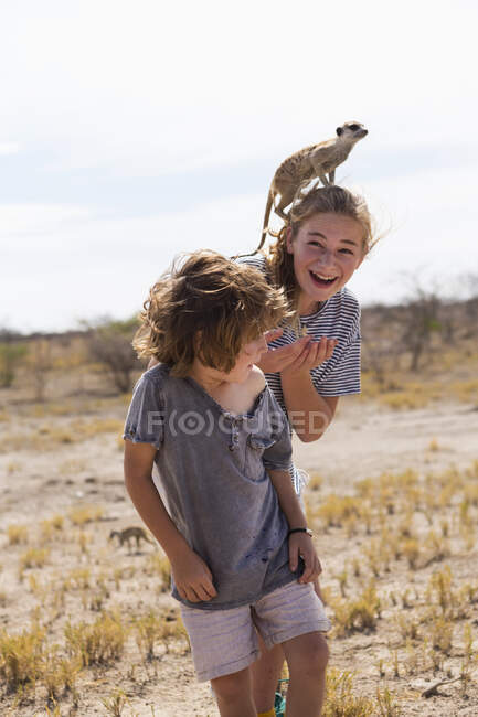 Ragazzo e ragazza di 5 anni con Meerkat in testa, Kalahari Desert, Makgadikgadi Salt Pans, Botswana — Foto stock