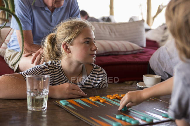 Famiglia in vacanza, persone che giocano a backgammon in un campo tenda in una riserva naturale. — Foto stock