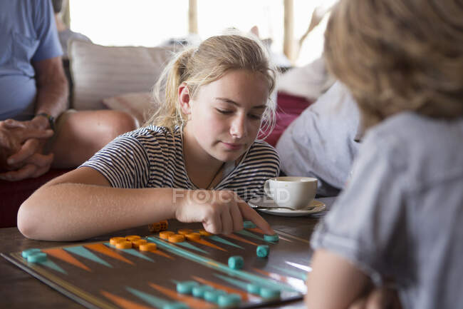 Une famille en vacances, des gens qui jouent au backgammon dans un camp de tentes dans une réserve faunique. — Photo de stock