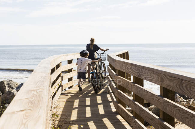 Two children, brother and sister on wooden bridge with bikes — Stock Photo