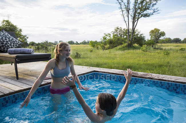Fratello e sorella, Due bambini nuotano in una piccola piscina in un campo safari — Foto stock