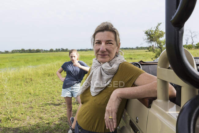 Portrait of adult woman leaning on safari vehicle, Botswana — Stock Photo
