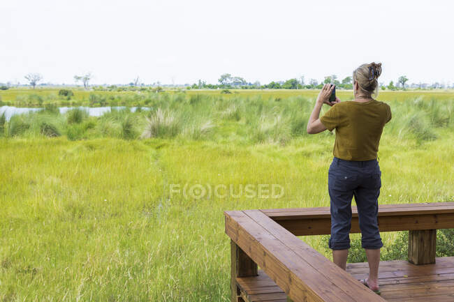Adult woman photographing scenic landscape, Botswana — Stock Photo