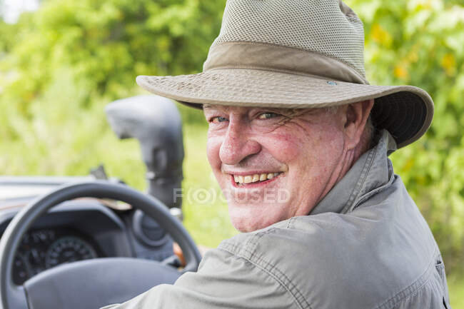 Retrato de un guía de safari sonriente en un sombrero de arbusto - foto de stock