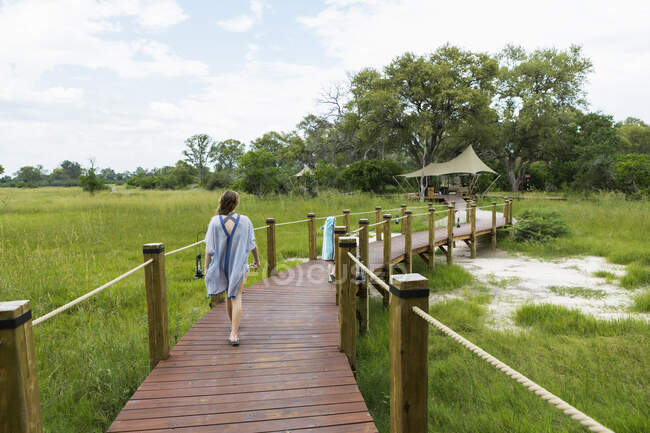 13 year old girl walking on wooden path, tented camp, Botswana — Stock Photo