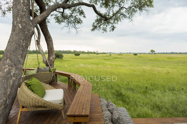Holzplattform mit Sitzgelegenheiten mit Blick auf Wiesen und Landschaft — Stockfoto