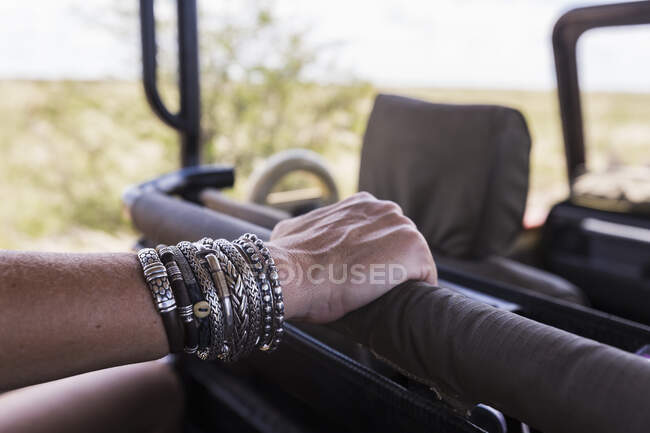 Close up of woman in bracelet jewelry in safari vehicle — Stock Photo