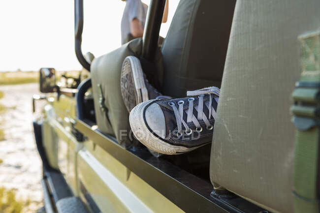 Plan recadré des pieds en baskets dans le véhicule safari — Photo de stock