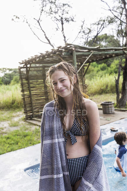 Sorrindo 13 anos de idade menina por uma piscina em um resort safari. — Fotografia de Stock