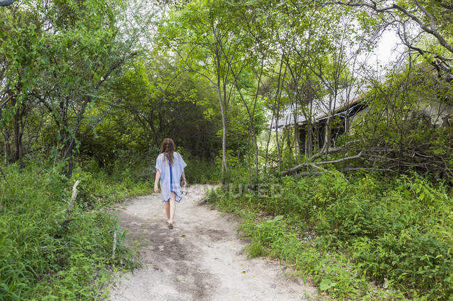 Menina de 13 anos caminhando em caminho de terra para acampamento tentada, Maun, Botsuana — Fotografia de Stock