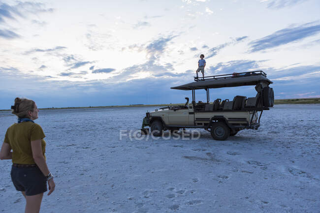 Garçon de 6 ans debout sur un véhicule safari, Nxai Pan, Botswana — Photo de stock
