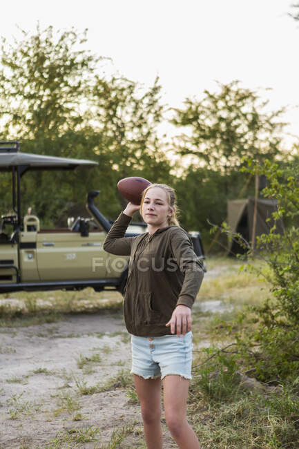 13 year old girl throwing football at tented camp, Botswana — Stock Photo