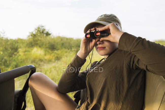 Menina de 13 anos com binóculos no veículo safari, Botswana — Fotografia de Stock