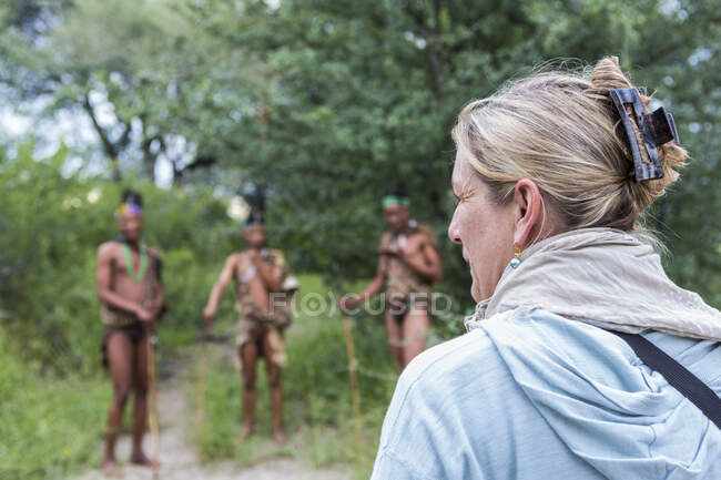 Turista em uma trilha a pé com membros do povo San, homens do mato. — Fotografia de Stock