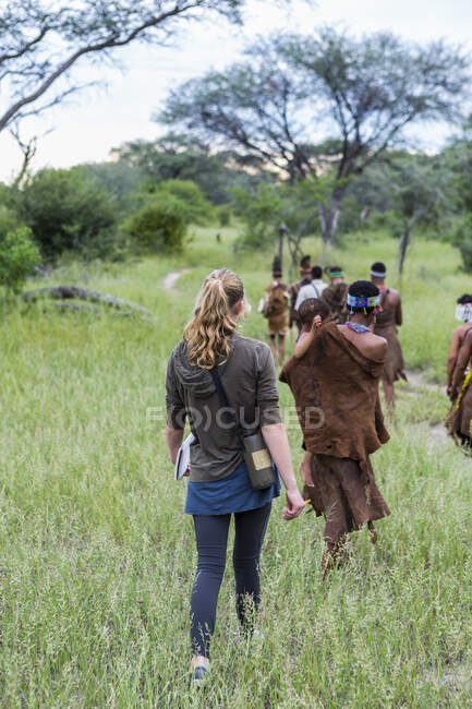Turistas en un sendero con miembros del pueblo de San, bosquimanos en Botsuana - foto de stock