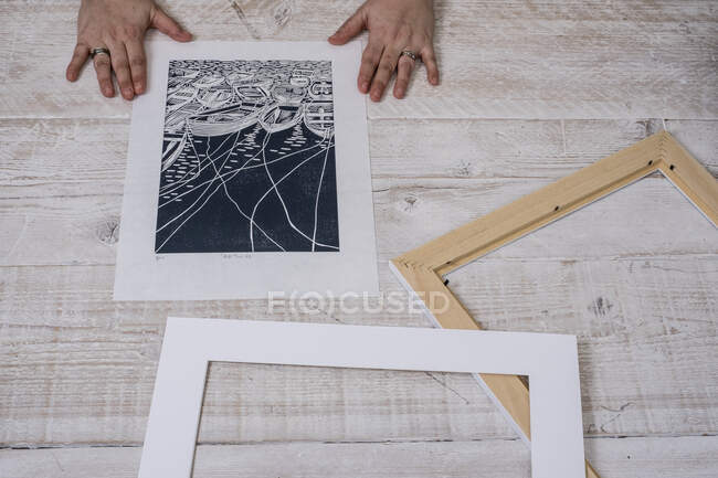 Eine Person, die einen Lino in einen Rahmen und Bilderrahmen einrahmt. — Stockfoto