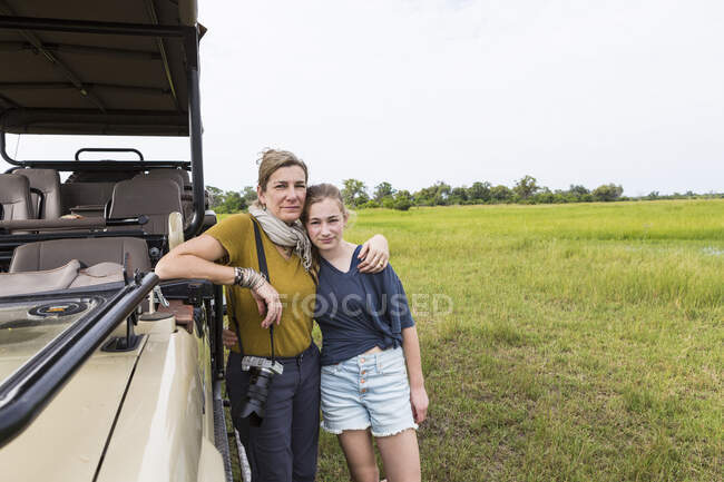Mãe com filha adolescente perto de veículo de safári, Botswana — Fotografia de Stock