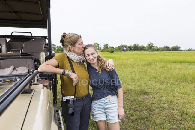 Mother with teen daughter near safari vehicle, Botswana — Stock Photo