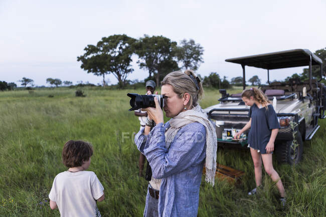 POST DIESE ONLINE NICHT BIS JUNI 2022! Mutter beim Fotografieren auf Safari bei Sonnenuntergang, Botsuana — Stockfoto