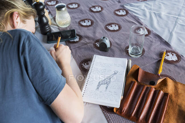 A thirteen year old girl writing in her journal, tented camp, Botswana — Stock Photo