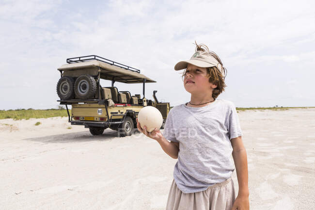 Ragazzo che sorregge un grande uovo di struzzo — Foto stock