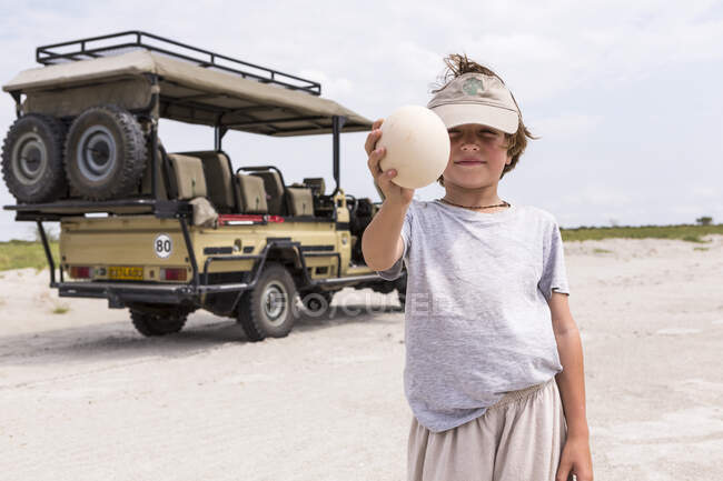 Niño sosteniendo un huevo de avestruz grande - foto de stock