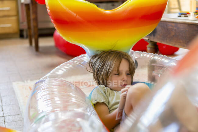 Garçon de 5 ans reposant dans la piscine flottant à la maison — Photo de stock