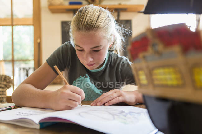 12 anno vecchio ragazza disegno in schizzo pad a casa — Foto stock