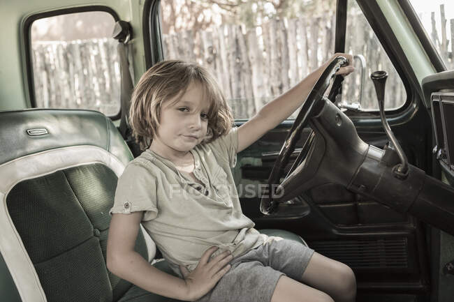 5-jähriger Junge am Steuer eines Pick-ups aus den 1970er Jahren, NM. — Stockfoto
