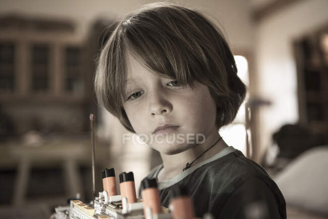Menino de 5 anos brincando com seu barco de brinquedo em casa — Fotografia de Stock