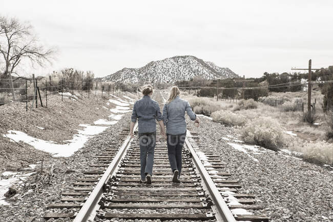 Preteen girls friends walking railroad tracks together, NM. — Stock Photo