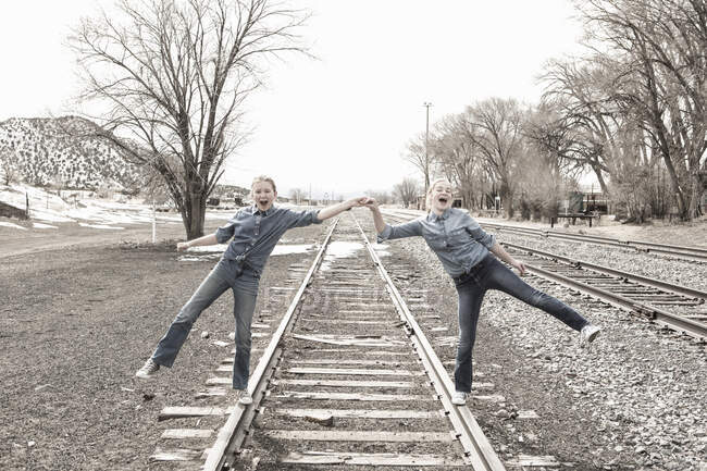 Preteen meninas amigos caminhando trilhas ferroviárias juntos, NM. — Fotografia de Stock