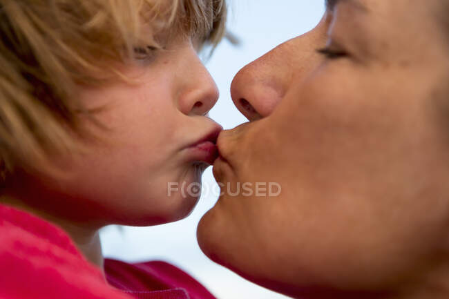Close up of mother kissing her 5 year old son — Stock Photo
