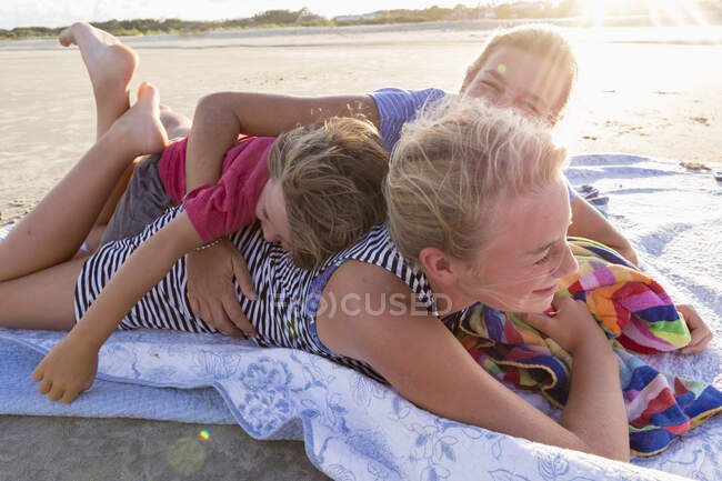 Madre y sus hijos en la playa al atardecer, Georgia - foto de stock