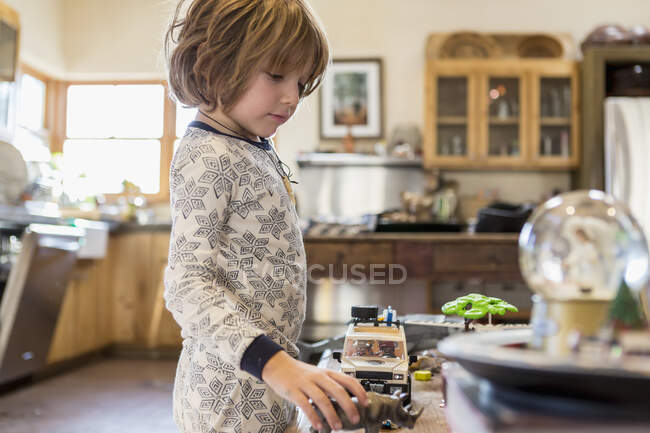 4 year old boy wearing pajamas playing with toys at home — Stock Photo