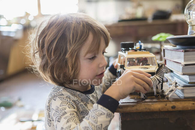 4 year old boy wearing pajamas playing with toys at home — Stock Photo