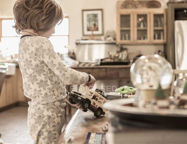 4 anno vecchio ragazzo indossare pigiama giocare con giocattoli a casa — Foto stock
