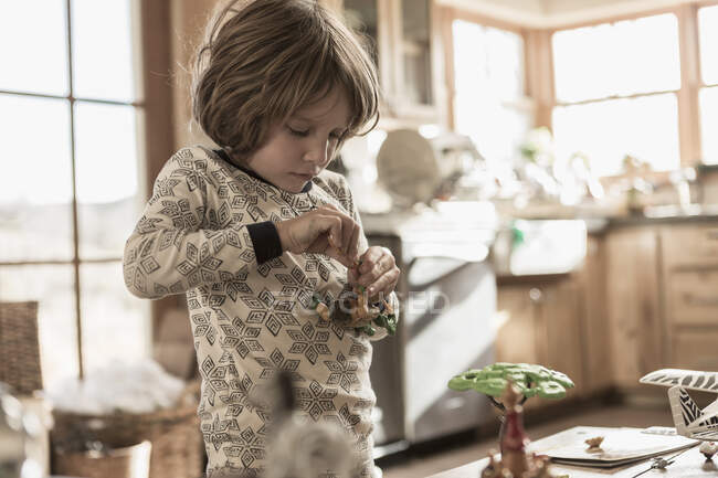 4 anno vecchio ragazzo indossare pigiama giocare con giocattoli a casa — Foto stock