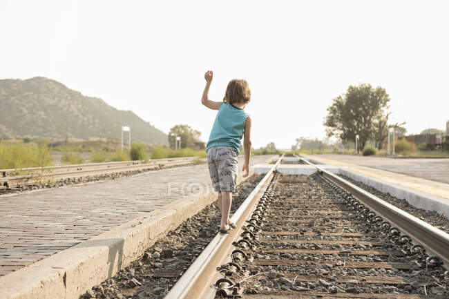 Niño de 4 años balanceándose en vía férrea, Lamy, NM. - foto de stock