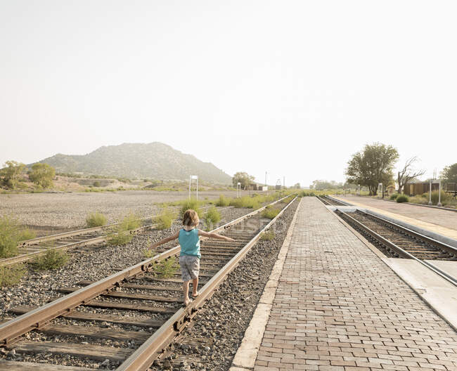 4 anno vecchio ragazzo bilanciamento su ferrovia pista, Lamy, NM. — Foto stock