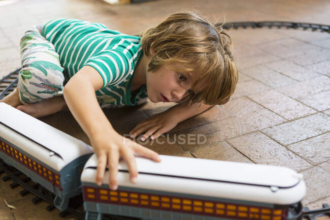 Garçon de 4 ans jouant avec le train jouet — Photo de stock