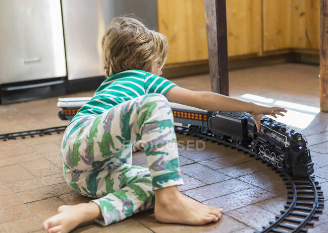 Niño de 4 años jugando con el tren de juguete - foto de stock