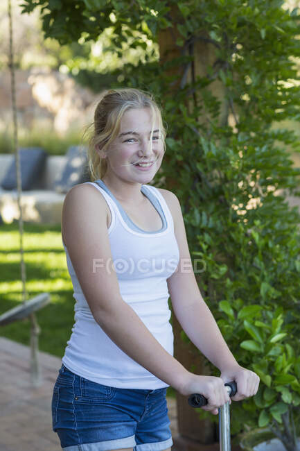 Porträt des süßen lächelnden 11-jährigen Mädchens auf dem Roller — Stockfoto