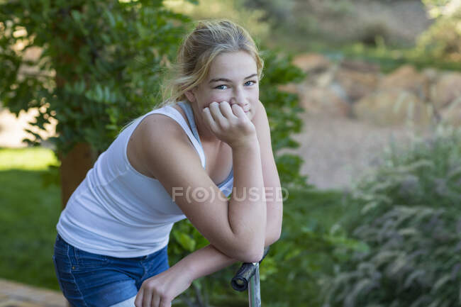 Portrait of cute smiling 11 year old  girl on scooter — Stock Photo